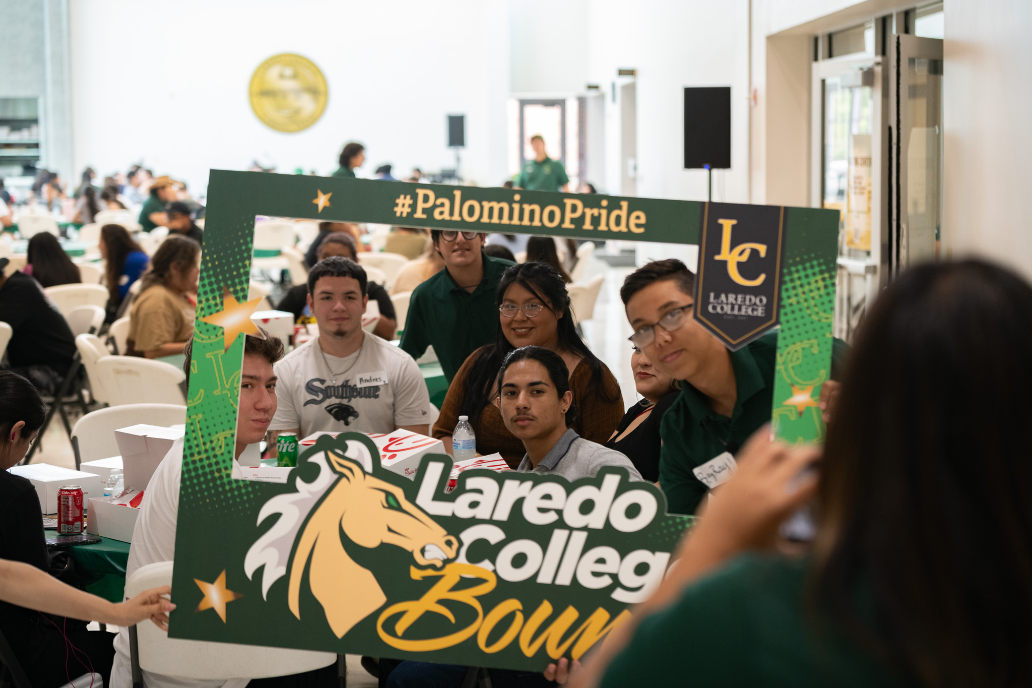 students gather for photo with frame